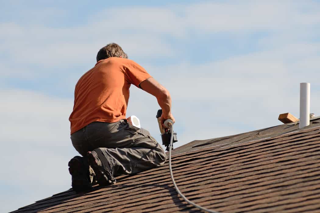 Roofing contractor working on asphalt roof